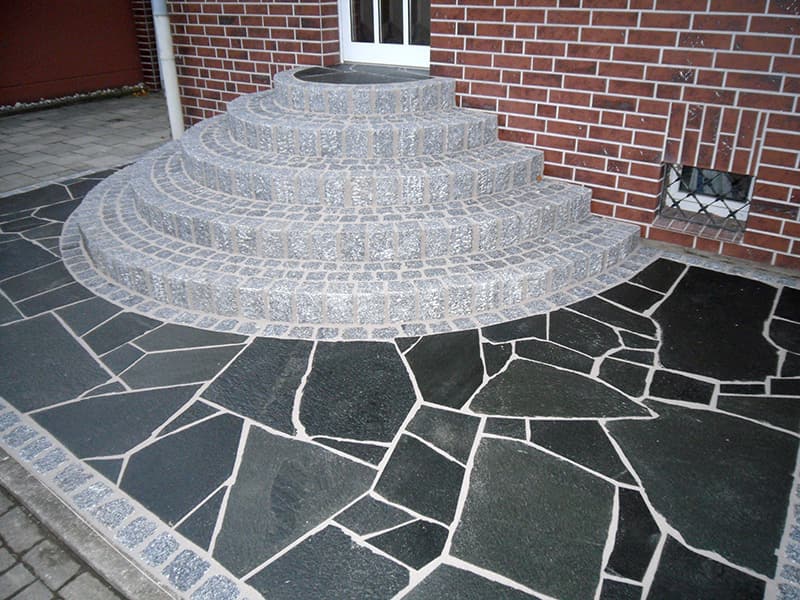 Dunkle Quarzit-Polygonalplatten, kombiniert mit Granit-Palisaden