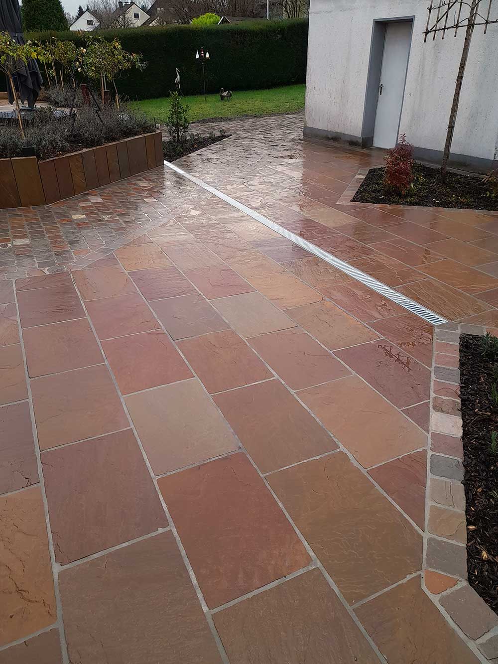 Naturstein-Terrassengestaltung mit Einfasung und Wegen